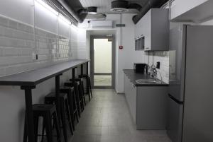 eine Küche mit einer langen Theke und Hockern in der Unterkunft AV-3 capsule hotel in Kiew