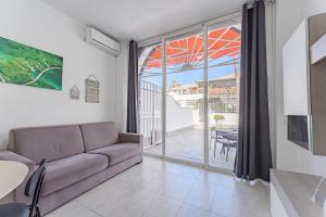 a living room with a couch and a view of a patio at APARTAMENTO EN PARQUE SANTIAGO II in Arona