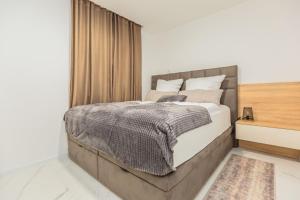a bedroom with a large bed and a window at Delux apartments Selina in Baška Voda