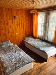 two beds sitting in a room with a window at Domki letniskowe in Śliwin