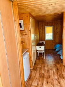 a room with a refrigerator and a desk in a cabin at Domki letniskowe in Śliwin