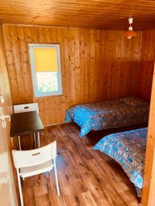 a room with two beds and a desk in a cabin at Domki letniskowe in Śliwin