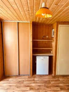 a kitchen with a small refrigerator and a light at Domki letniskowe in Śliwin