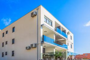 a white apartment building with blue balconies at Delux apartments Selina in Baška Voda