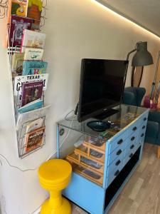 een tv op een dressoir met een bureau bij GETGYR Hostel in Holbæk