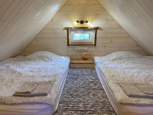 two beds in a attic bedroom with a mirror at Reiu majake in Reiu