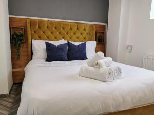 1 dormitorio con 1 cama blanca grande y toallas. en Selborne House en Havant