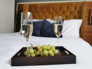 dos copas de champán y una bandeja de uvas en una cama en Selborne House en Havant