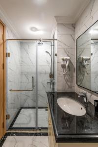 y baño con ducha acristalada y lavamanos. en StaynFun Homestay - Vinhomes Ocean Park 2, en HÆ°ng YÃªn