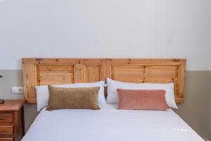 um quarto com uma grande cama branca e 2 almofadas em Verdi 254 em Barcelona
