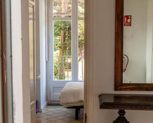 um quarto com uma porta, um espelho e uma cama em Verdi 254 em Barcelona