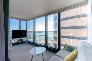 un soggiorno con divano e una grande finestra di Magnificent Harbour View Skytower View Apartment in CBD ad Auckland