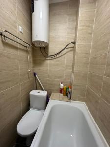a bathroom with a toilet and a bath tub at 1 комн.квартира in Balqash +2 photos