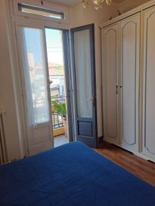a bedroom with a blue bed and sliding glass doors at Appartamento Via Comune Antico in Milan