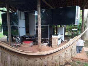 a hammock in a house with a large screen at Trailer de Viagem no Rancho Santo Sol in Pederneiras