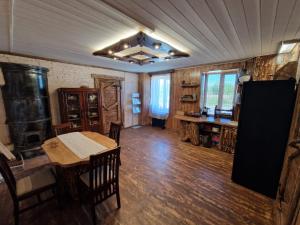 a living room with a table and a stove in it at Bajāri - Viesu Māja in Svente