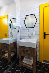 a bathroom with two sinks and two mirrors at Limon Inn Hotel, Taşucu in Tasucu