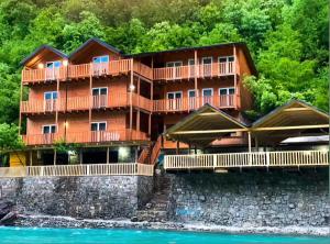 a large building on the side of a river at Livadhi Guesthouse in Mollʼ e Shoshit