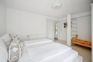 - une chambre blanche avec 2 lits et un banc dans l'établissement Haus König Ferienwohnung 2 in Lichtenhain, à Sebnitz