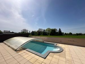 una piscina con un tobogán en un patio en Le DaubenLand, en Daubensand