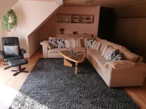 sala de estar con sofá y silla en Ländliche, ruhige Ferienwohnung nahe der Nordsee, ideal zur Entspannung und für Umgebungsausflüge, en Fjerritslev