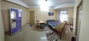 - un salon avec un lit et une porte violette dans l'établissement Elegance Delight- Entire 2BHK spacious Flat, à Guwahati