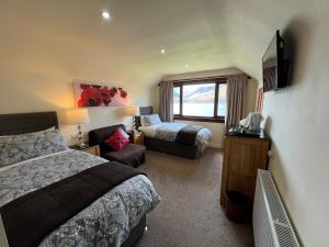 a hotel room with a bed and a couch at Stronchreggan View Guest House in Fort William