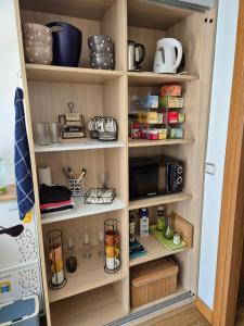 a kitchen pantry with wooden shelves filled with food at Pension Joakina in San Sebastián