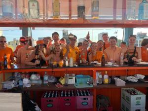 a group of people posing for a picture behind a bar at Saigon Rooftops Hostel in Ho Chi Minh City