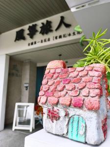 a gingerbread house on a table in front of a building at Kite Hostel in Chiayi City