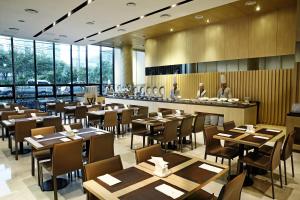 ein Restaurant mit Holztischen und -stühlen und einer Bar in der Unterkunft Hotel The One in Jeju-do