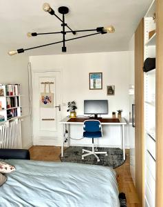 - une chambre avec un bureau, un ordinateur et une chaise bleue dans l'établissement Chambre dans appartement élégant proche de Paris, à Suresnes