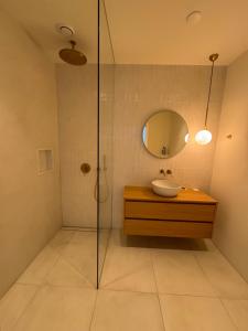 een badkamer met een douche, een wastafel en een spiegel bij Old South - Luxury Apartment in Amsterdam