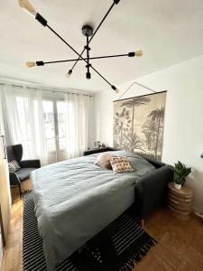 - une chambre avec un grand lit et un lustre dans l'établissement Chambre dans appartement élégant proche de Paris, à Suresnes