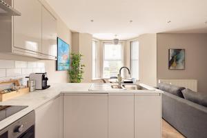 a kitchen with white cabinets and a sink at Charles Hope Plymouth in Plymouth