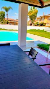 una terrazza con 2 sedie e una piscina di La casa di Elisa villa con piscina a San Leone