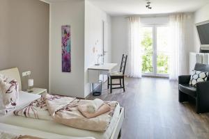 1 dormitorio con cama, silla y escritorio en Schwanenhof Hotel und Restaurant en Erkelenz