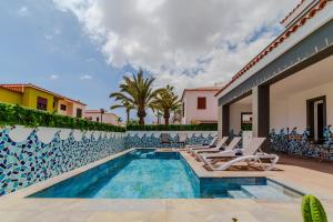 a villa with a swimming pool and lounge chairs at Villa in south of Tenerife in Costa Del Silencio