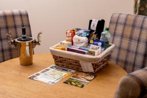a basket of food and drinks on a table at Courtyard Cottage 3, Riverside Cottage in Fort Augustus