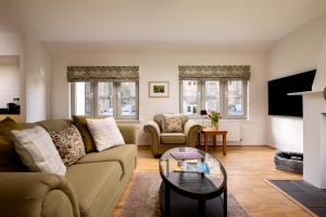 a living room with a couch and a table at Courtyard Cottage 3, Riverside Cottage in Fort Augustus