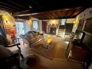 uma sala de estar com um sofá e uma lareira em 17th century cottage on farm in Vale of Glamorgan em Bonvilston