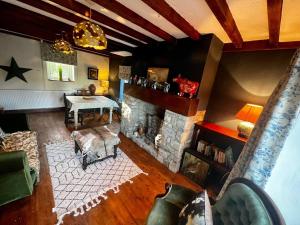 een woonkamer met een open haard bij 17th century cottage on farm in Vale of Glamorgan in Bonvilston