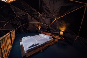 um quarto com uma cama numa parede preta em NİLS DOME SAPANCA em Sakarya