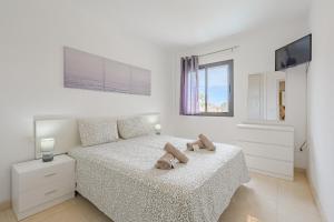 a white bedroom with a bed with towels on it at Casa independiente con piscina privada in Adeje +41 photos