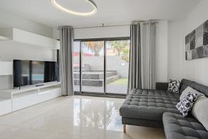 a living room with a couch and a tv at Casa independiente con piscina privada in Adeje