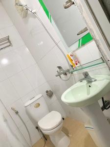 a white bathroom with a toilet and a sink at Friendly room in Hai Phong