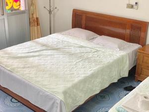 a bedroom with a large bed with a wooden headboard at Friendly room in Hai Phong