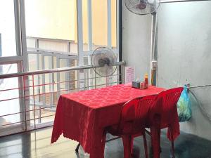 a red table with two chairs and a fan at Friendly room in Hai Phong