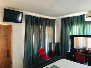 a hotel room with green curtains and red chairs at Khayalami Guest House in Mahalapye