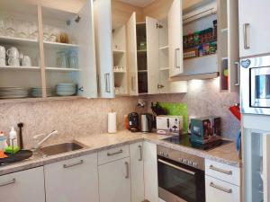a kitchen with white cabinets and a sink at 4-Zi-WG Casa Sogno - Valle mit Kamin. Alleinlage im Rebberg! in Agarone +19 photos